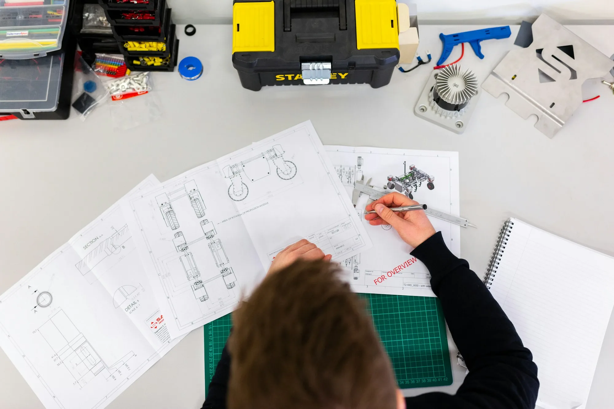 An engineer working over drawings at a workbench
